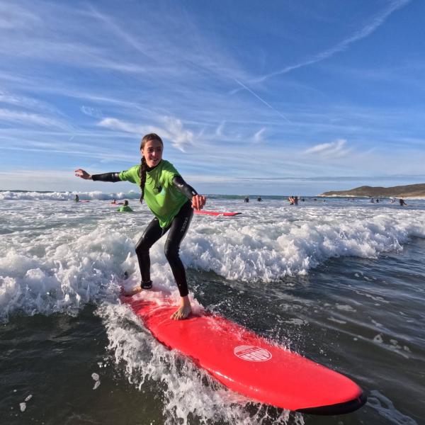 Girl surfing a wave on Woolacombe beach
